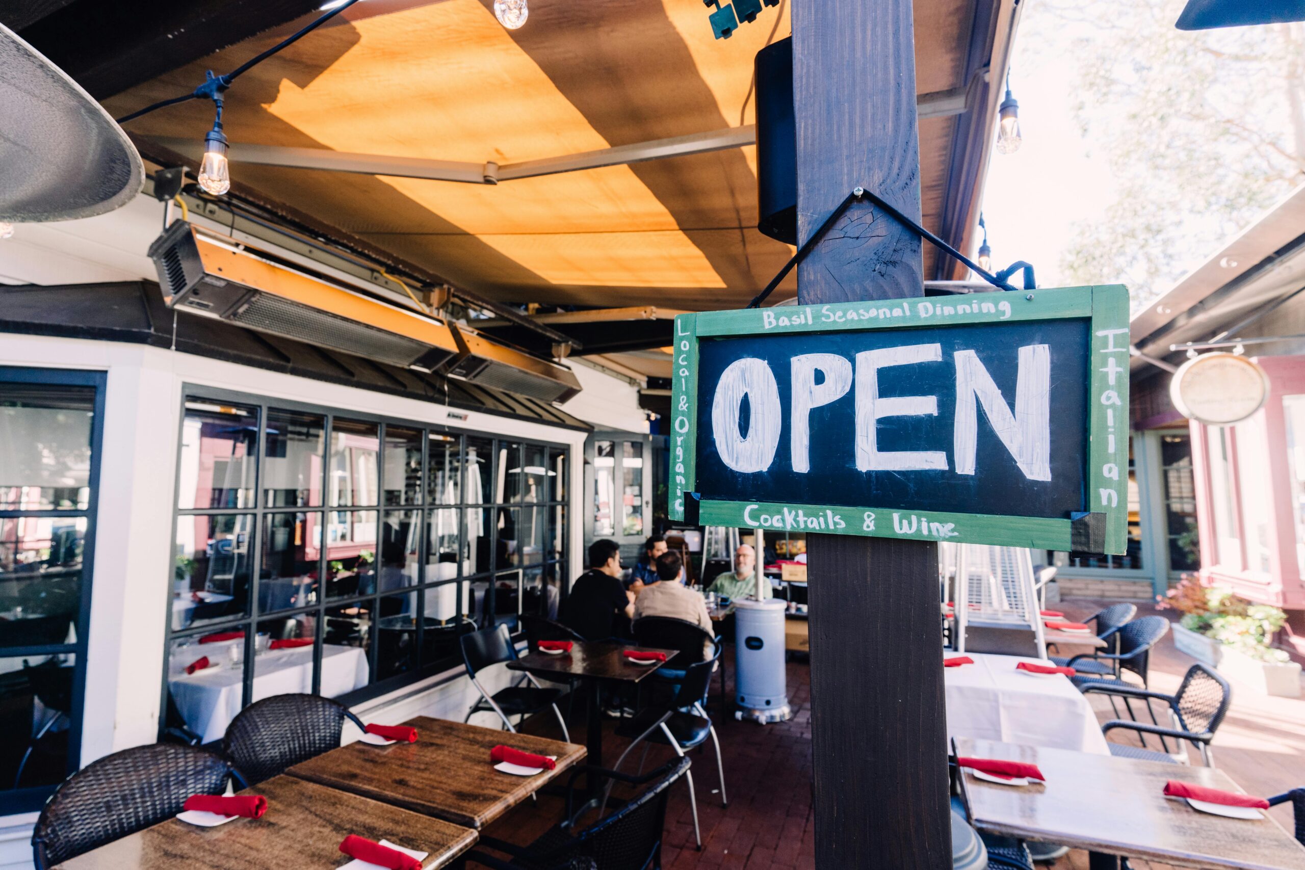 Charming outdoor café with open sign, patio seating, and inviting ambiance.