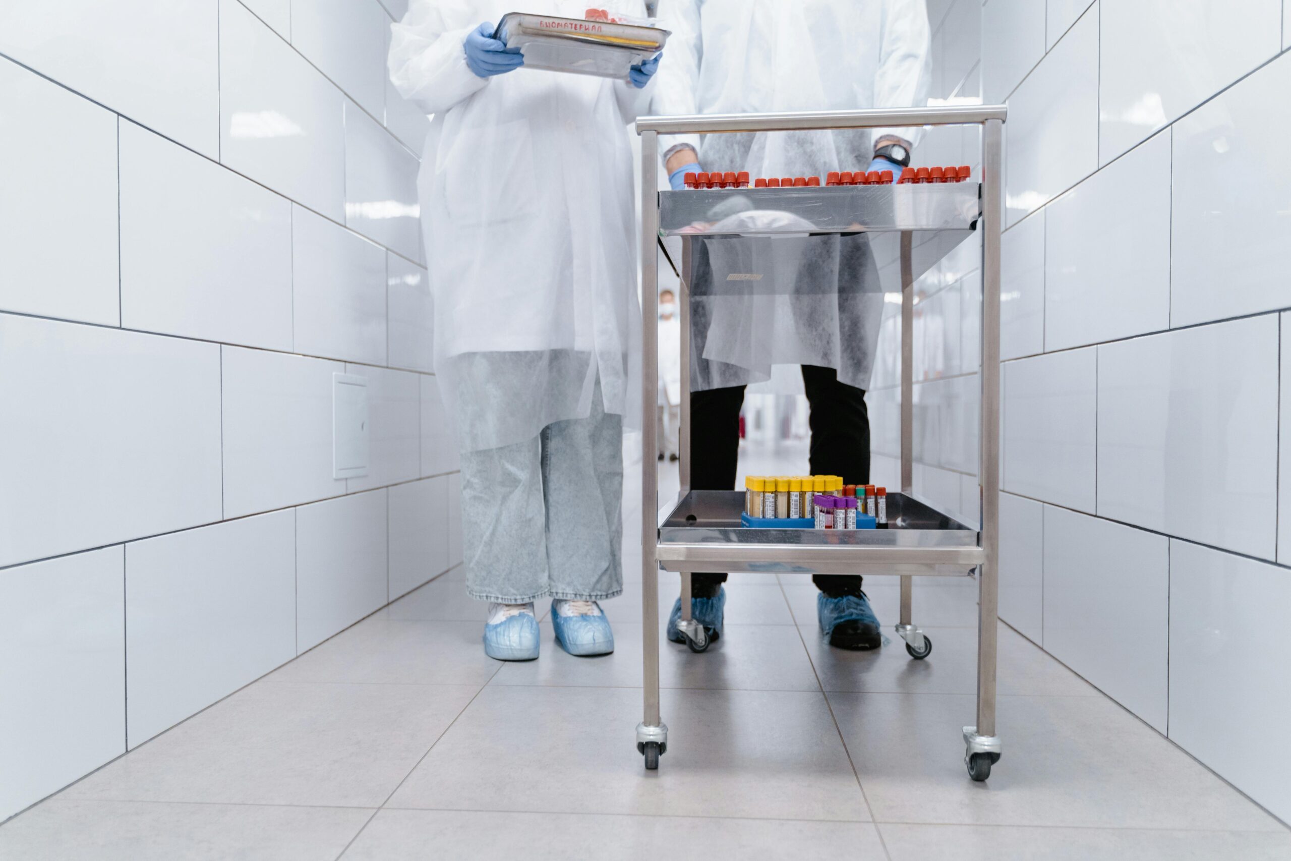 Healthcare professionals in protective gear moving samples in a clinical setting, enhancing safety and precision.